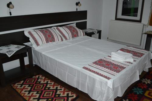 a bedroom with a bed with two pillows and a rug at Casa Lia in Valea Putnei