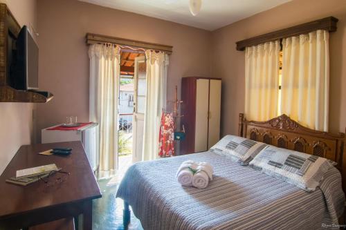 - une chambre avec un lit et 2 serviettes dans l'établissement Pousada Portal, à Tiradentes