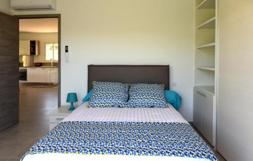 - une chambre dotée d'un grand lit avec des draps bleus et blancs dans l'établissement Sarl Valinco Locations, à Olmeto