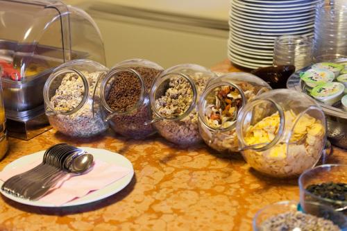 a table topped with containers filled with different types of food at Hotel Villa Isabella in Brenzone sul Garda