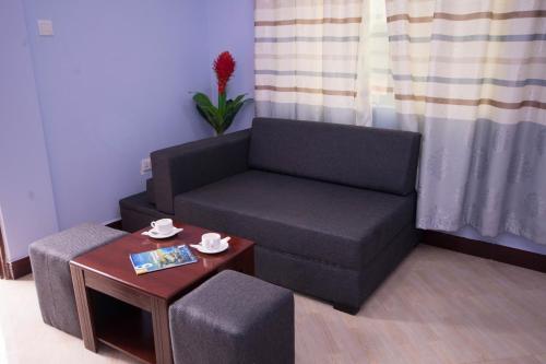 a living room with a couch and a table at Green Mountain Hotel in Arusha