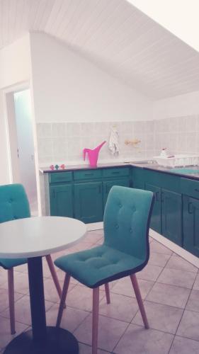 a kitchen with blue cabinets and a table and chairs at Voyage in Varaždin