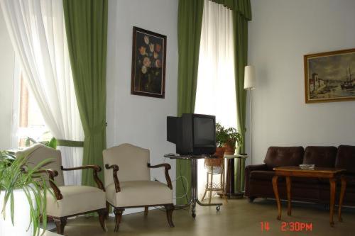 sala de estar con 2 sillas y TV en Hostal Excelsior en Madrid
