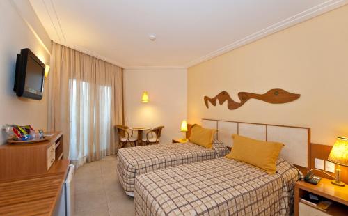 Cama ou camas em um quarto em Pontalmar Praia Hotel