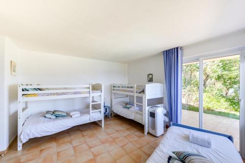 une chambre avec deux lits superposés et une fenêtre dans l'établissement La Veglia, à Porto-Vecchio