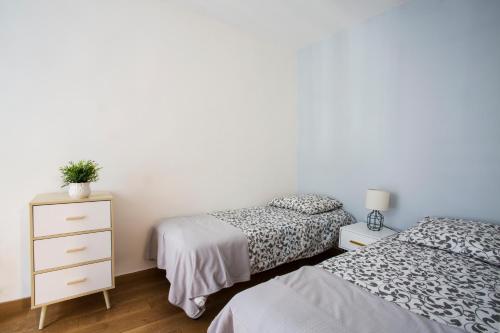 ein Schlafzimmer mit 2 Betten und eine Kommode mit einer Pflanze darauf in der Unterkunft Rue du Temple - Le Marais in Paris