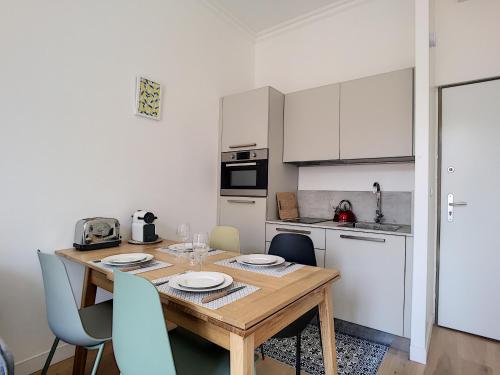 une petite cuisine avec une table et des chaises en bois dans l'établissement Nestor&Jeeves - CAESARS - Hyper center - Shopping avenue, à Nice