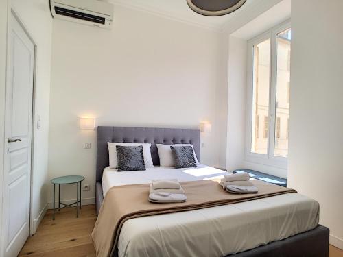 - une chambre blanche avec un grand lit et 2 serviettes dans l'établissement Nestor&Jeeves - CAESARS - Hyper center - Shopping avenue, à Nice