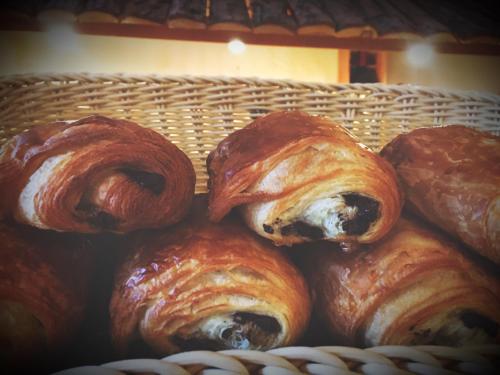 a basket filled with croissants and other pastries at Hôtel Plein Sud et piscine *** in Saint-Chaffrey