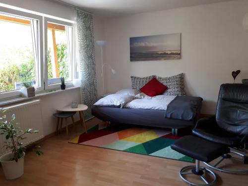 ein Wohnzimmer mit einem Sofa und einem Stuhl in der Unterkunft Gästewohnung Leinetal in Alfeld
