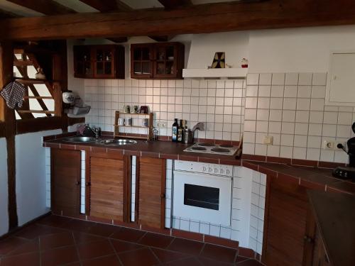 eine kleine Küche mit Herd und Spüle in der Unterkunft Diebacher Hof in Büdingen