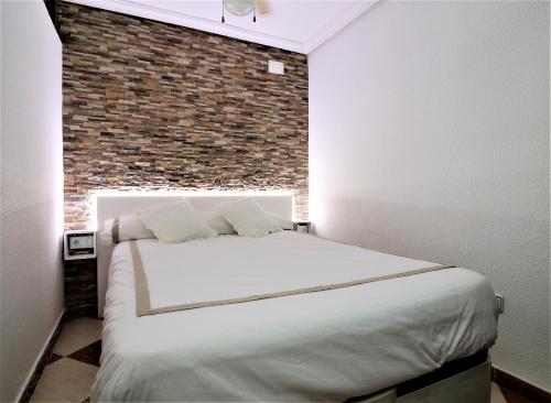 ベニドルムにあるLas Damas 23-Eのレンガの壁のベッドルーム1室(白いベッド1台付)