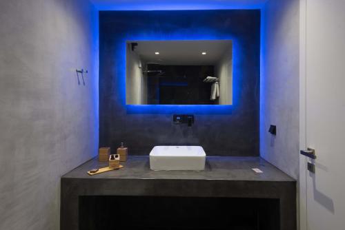 a bathroom with a white sink and a mirror at Calme Suites Mani in Agios Nikolaos
