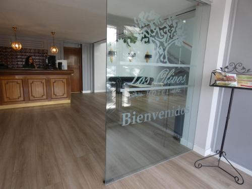 two images of a room with a glass wall at Hotel Los Olivos in Getafe
