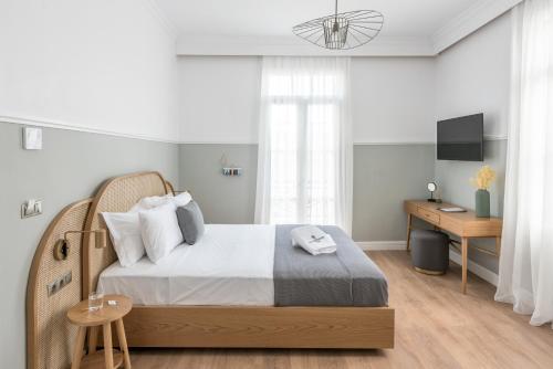 a bedroom with a large bed and a desk at The Anthemion House in Kavala