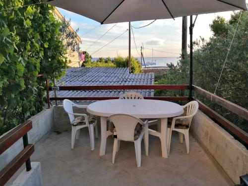 a table and chairs and an umbrella on a patio at Apartments Mira in Velike Kuknjare