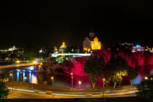 a city at night with a river and a bridge at King Gorgasali in Tbilisi City