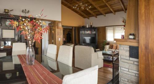 comedor con mesa de cristal y sillas blancas en Casa Labian Cabañas en San Carlos de Bariloche