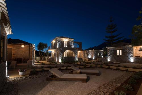 a house with lights on it at night at Calme Suites Mani in Agios Nikolaos