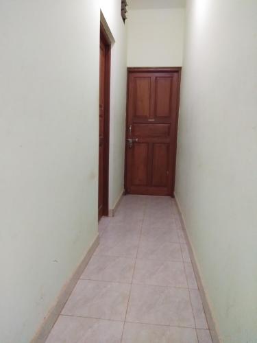 an empty hallway with a door and a tile floor at Luiza Guest House in Baga