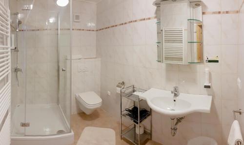 a white bathroom with a sink and a toilet at Thermenpension Gigler in Bad Waltersdorf