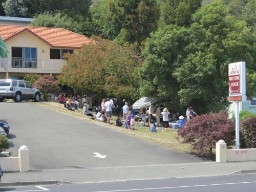 a group of people sitting on the side of a road at Abelia Motor Lodge in Nelson