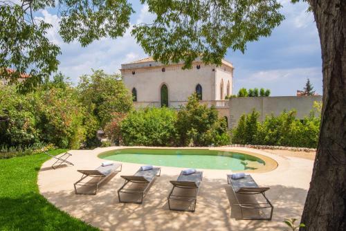 a patio area with a pool and lawn chairs at Villa Boscarino in Ragusa