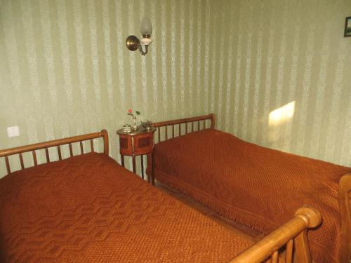 a bedroom with two beds and a side table at Guest House Kamea in Sighnaghi
