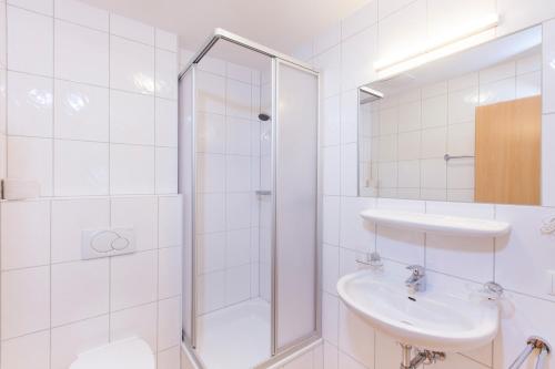 biała łazienka z prysznicem i umywalką w obiekcie Casa Bianco w Solden