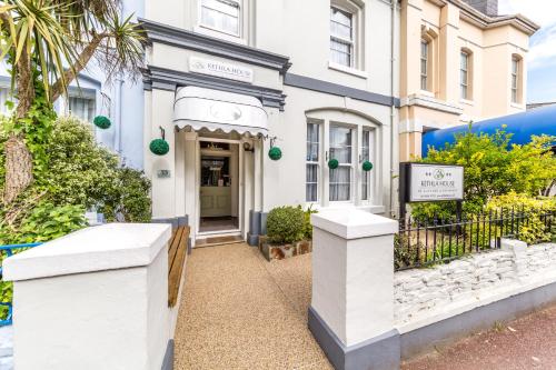 a white building with a sign in front of it at Kethla House in Torquay