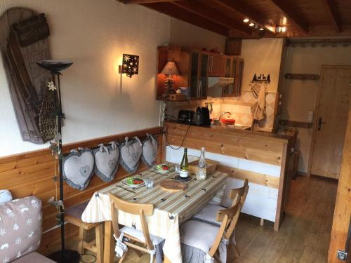 uma sala de jantar com uma mesa e cadeiras num quarto em Appartement chalet PRA LOUP 1600 La sapinière em Pra-Loup