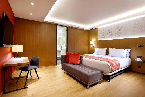 a bedroom with a bed and a chair and a desk at Áurea Catedral by Eurostars Hotel Company in Granada