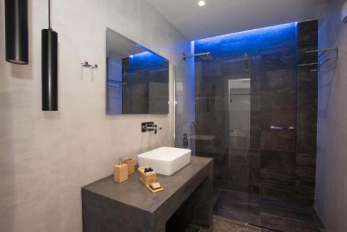 a bathroom with a sink and a shower at Calme Suites Mani in Agios Nikolaos