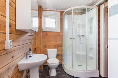 a bathroom with a toilet and a shower and a sink at Villa Falken in Åre