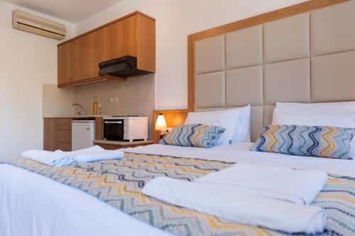 a bedroom with two beds and a kitchen at Pallazzo Fortezza in Rethymno Town