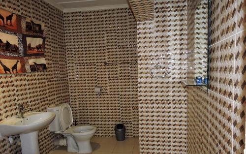 bagno con servizi igienici e lavandino di Threshold Lodge a Kasama