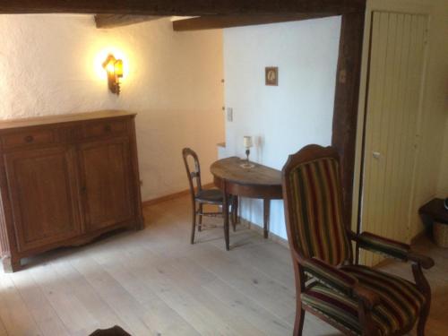 uma sala de jantar com uma mesa e cadeiras num quarto em La Truite Joyeuse em Saint-Hubert