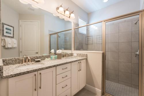 a bathroom with two sinks and a shower at Delightful Home Near Disney With Private Pool, Media Room, Waterpark & Resort Access At Encore Resort Reunion - 7418Mr in Kissimmee