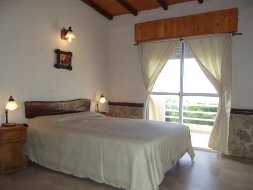 1 dormitorio con cama y ventana grande en Tano Gaucho en Las Toninas