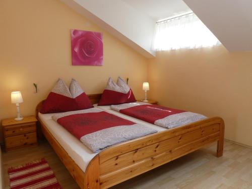 a bedroom with a large wooden bed with red pillows at Haus Daheim in St. Wolfgang