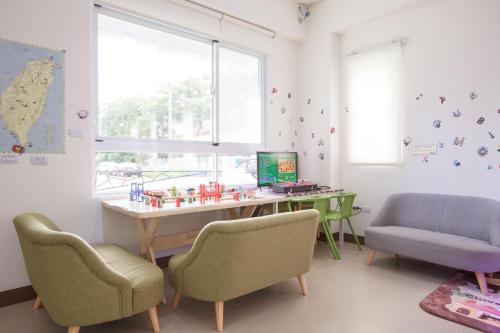a room with a desk and chairs and a window at 芹菜芋頭親子民宿 in Taitung City