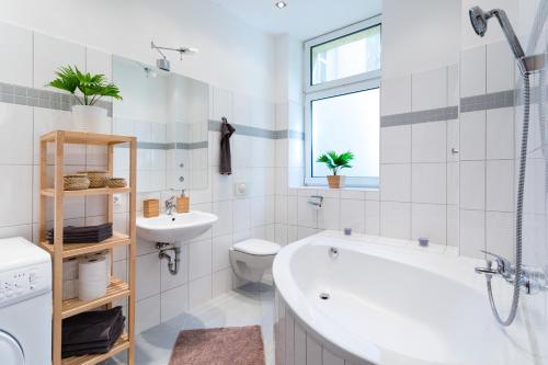a bathroom with a tub and a sink and a toilet at Der Schöne Ernst in Berlin