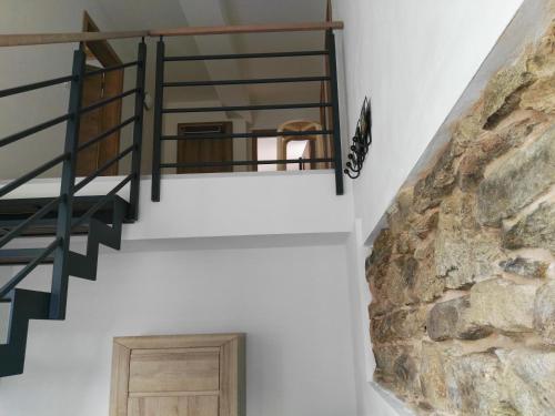 a staircase in a house with a stone wall at Apartmán "Na Třináctce" Březiny u Poličky 13 in Březiny