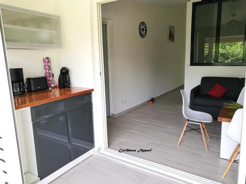 a kitchen with a counter and a chair in a room at Caribbean Appart' in Le Moule