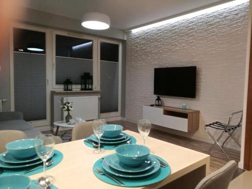 a living room with a table with plates and wine glasses at Apartament Mini in Lublin