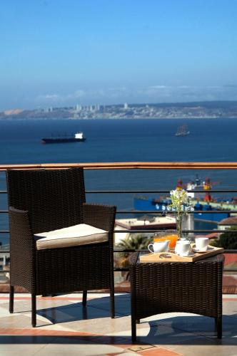 a table and chairs with a view of the ocean at Hotel Boutique Acontraluz in Valparaíso
