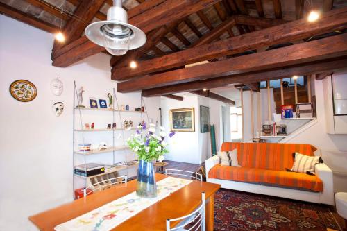 sala de estar con sofá naranja y mesa en Di Franco Super Attico, en Venecia