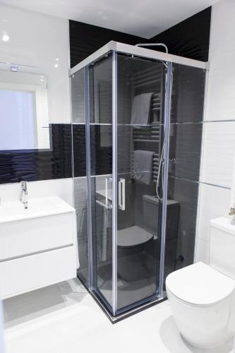 a bathroom with a glass shower and a toilet at Casa Rural El Mendrugo in Tornadizos de Ávila