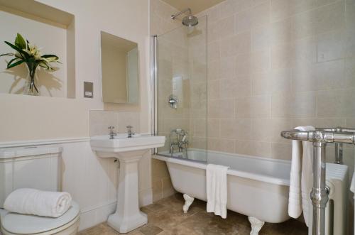 a bathroom with a tub and a sink and a toilet at Lady Margaret's in Bath