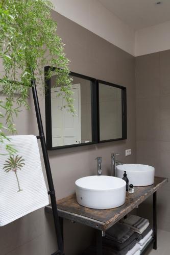 a bathroom with two sinks on a shelf with a mirror at Stylish * Sunny * Cosy House in Heemstede